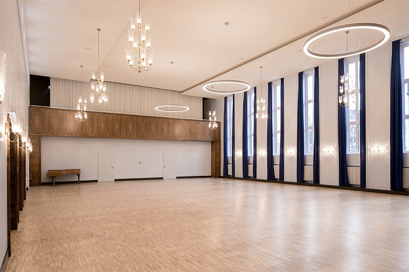 Großzügiger Veranstaltungssaal mit Kronleuchtern und hohen Fensterfronten