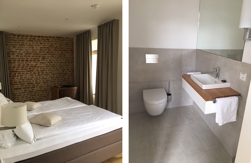 Schlafzimmer mit Backsteinwand sowie modernes Badezimmer mit wandhängendem Waschtisch