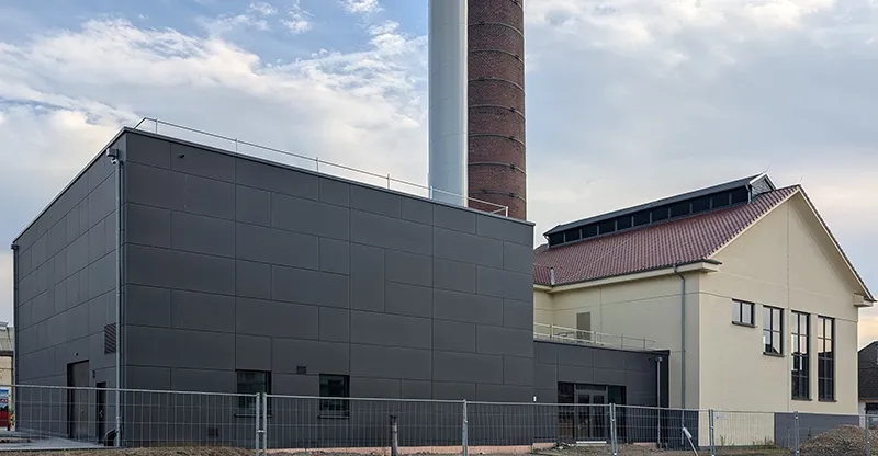 Modernes Industriegebäude mit Schornstein und klarer Fassadengestaltung