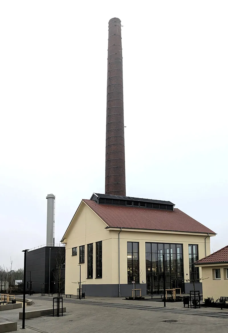 Modernes Gebäude mit Schornstein und verglastem Eingangsbereich