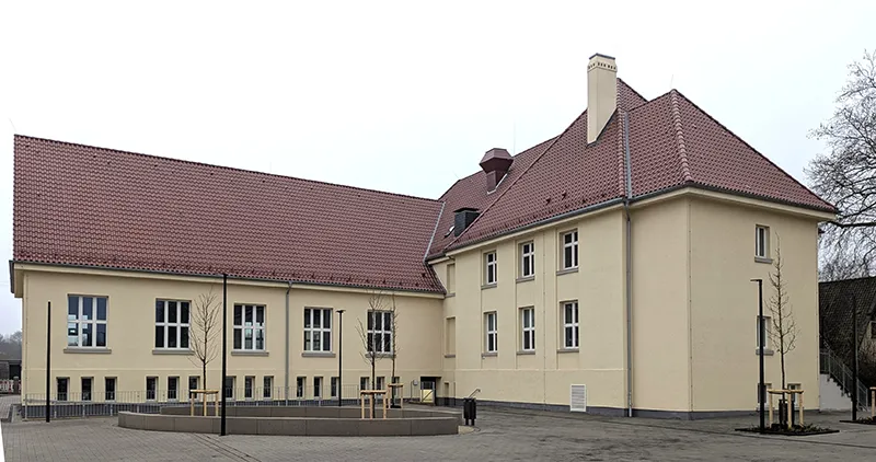 Modernisiertes Gebäudeensemble mit Satteldach und klar gegliederter Fassadengestaltung