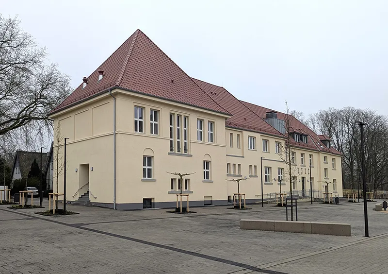 Modernisiertes Gebäudeensemble mit Satteldach und klar gegliederter Fassadengestaltung