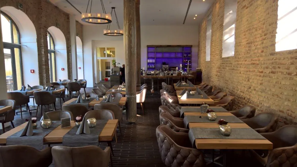 Restaurantbereich mit Backsteinwänden und Bar im Hintergrund