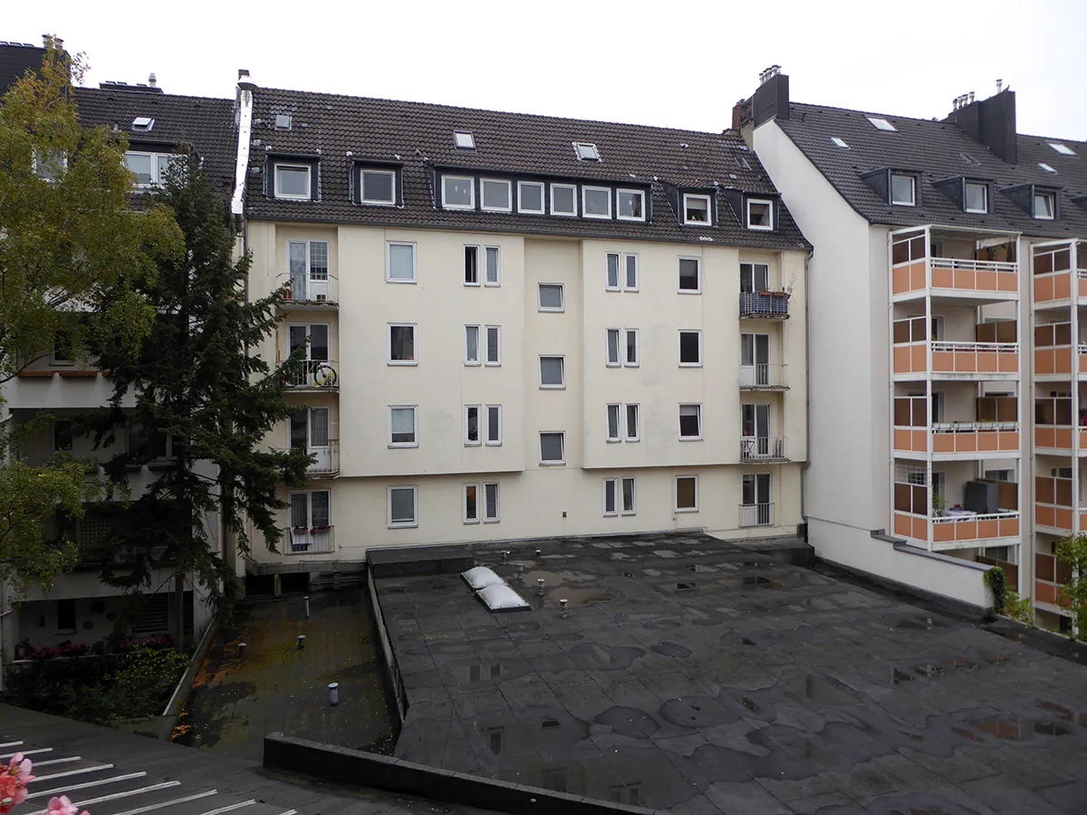 Bestandswohngebäude mit schlichter Putzfassade und Innenhofbereich