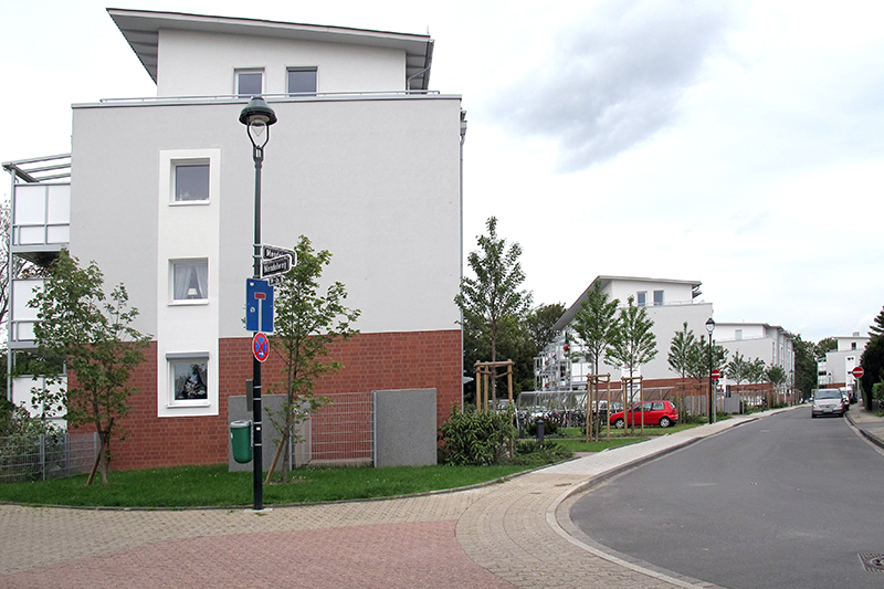 Modernes Wohnquartier mit klar gegliederter Fassade und Straßenansicht