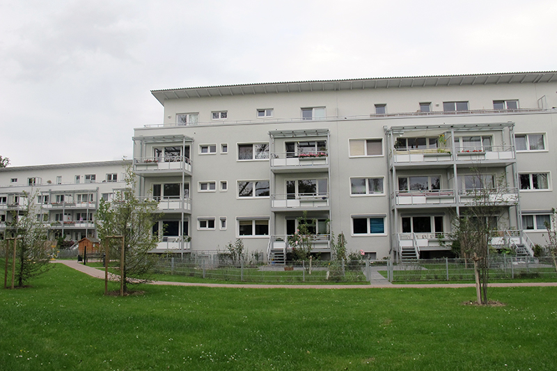 Modernes Wohngebäude mit Balkonen und großzügigem Grünbereich