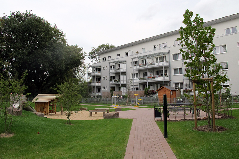 Modernes Wohnquartier mit Spiel- und Aufenthaltsbereichen im begrünten Innenhof