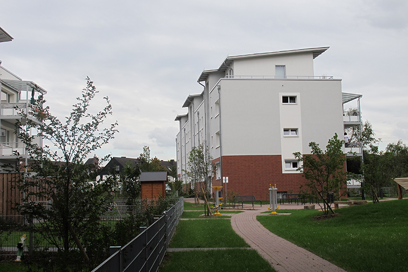 Modernes Wohnquartier mit klar gegliederter Fassade und begrüntem Innenbereich