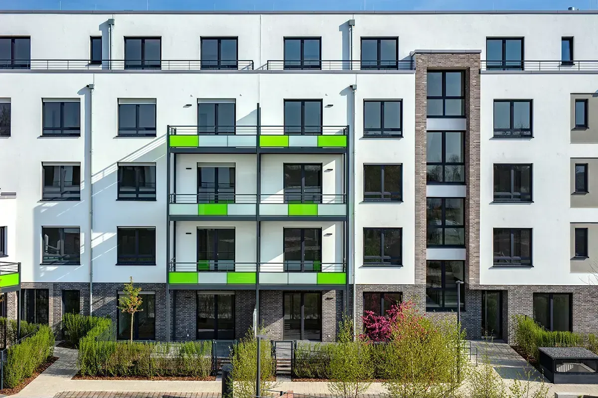 Modernes Mehrfamilienhaus mit Balkonen und farbigen Fassadenelementen